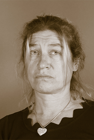 Sepia-Portrait einer Frau. Sie trägt helles, nach hinten gestecktes Haar und eine dunkle Bluse. Ihr Blick geht nach oben rechts, an der Kamera vorbei.